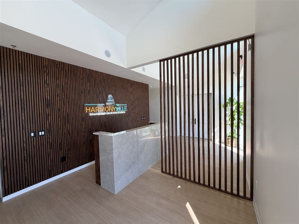Finished office reception with a walnut slat wall in DFW by i30 Builders