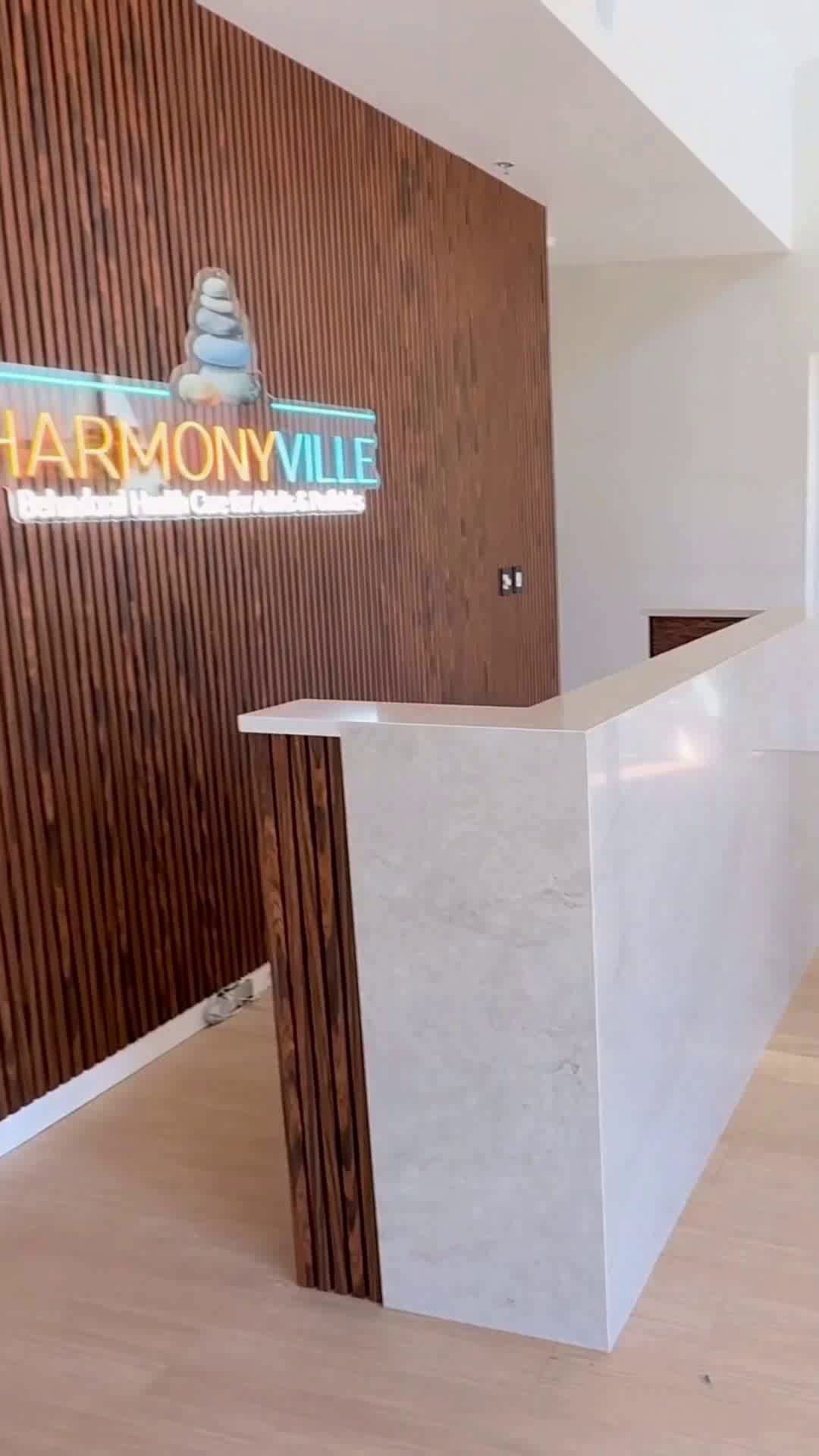 Completed tenant improvement reception with slat feature wall and marble desk