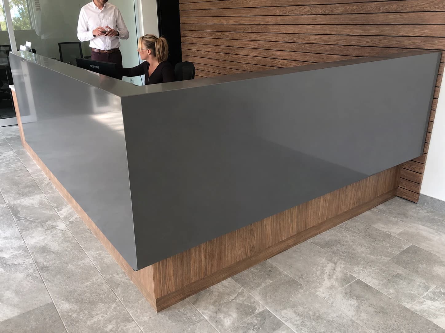 Gray quartz reception & walnut slat wall
