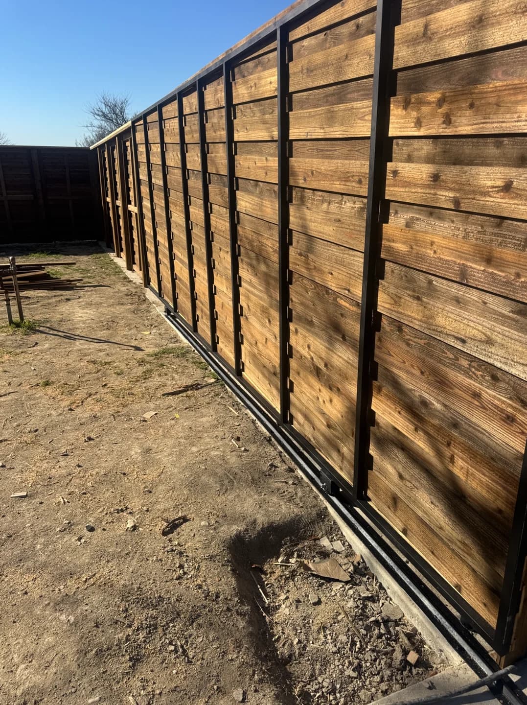 Horizontal cedar privacy fence on steel posts maintained level over grade transitions in Heath.
