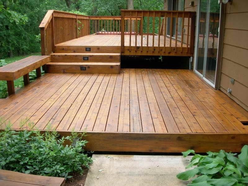 Two-level stained cedar deck with railings, wide steps and a built-in bench.