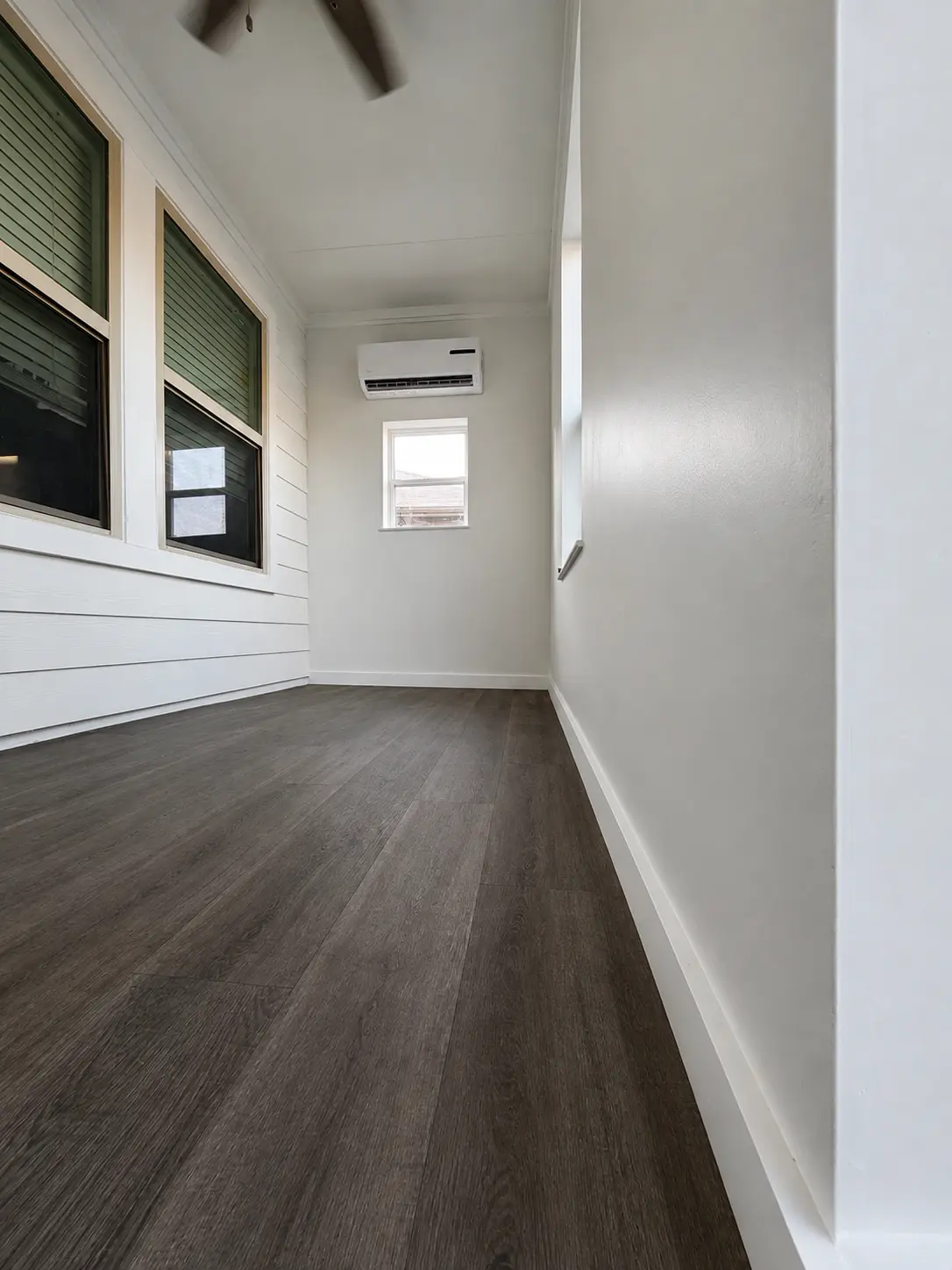 A home office we built in Crandall by closing in a covered patio: shiplap, plank flooring, a ceiling fan and a mini-split on its own circuit.