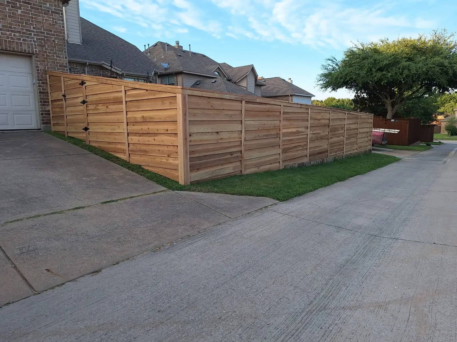 Horizontal cedar fence with a matching gate, running along a residential alley.
