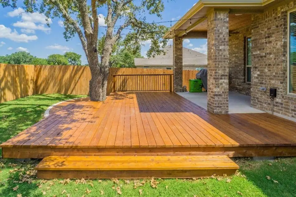 Stained cedar deck with a step, built around a mature tree.