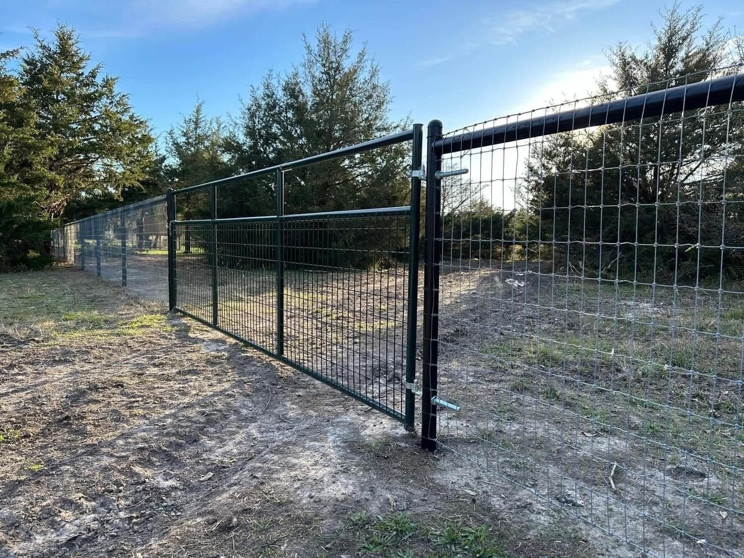 Welded-wire ranch fence with a matching steel pipe gate.