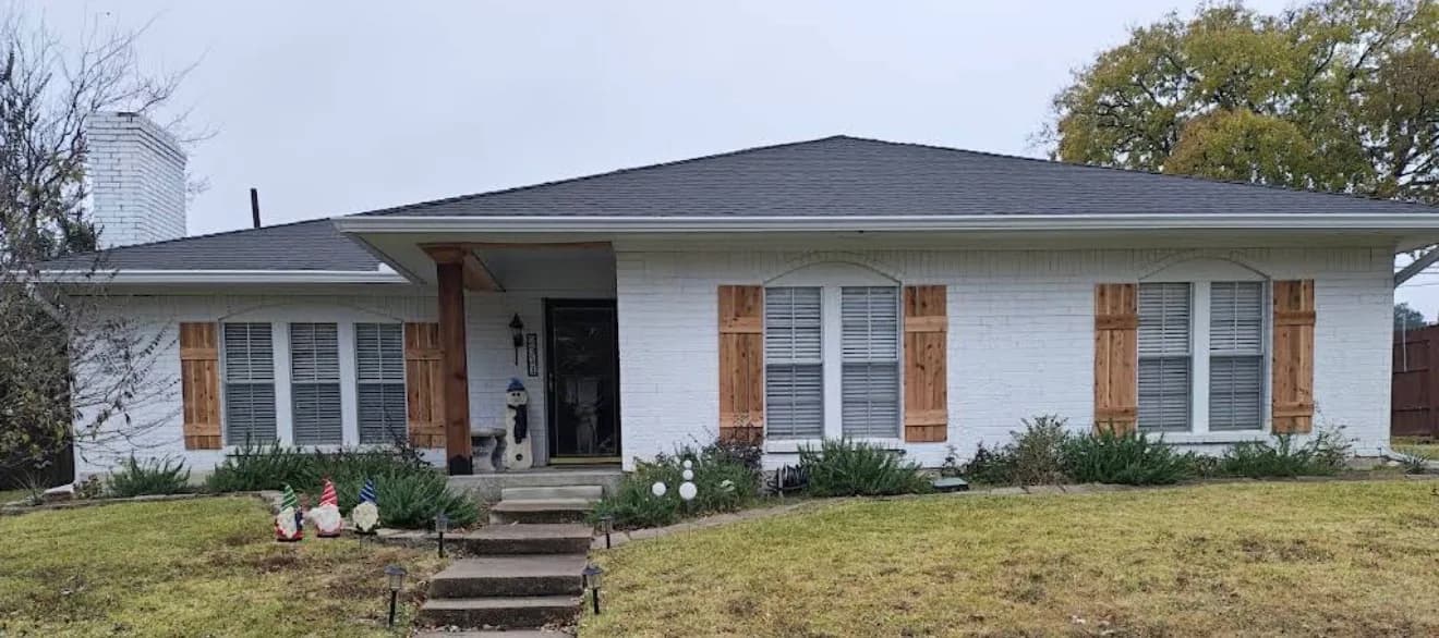Painted-white brick ranch home in Carrollton with new custom cedar board-and-batten shutters and a cedar porch column wrap.