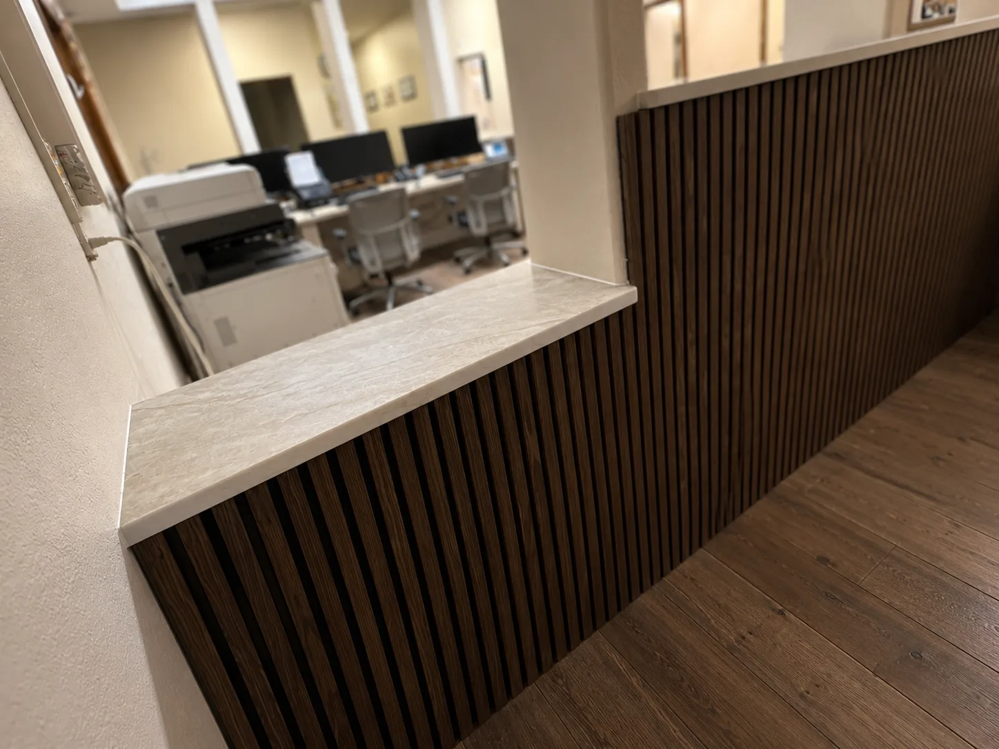 Quartz ledge over walnut slat millwork