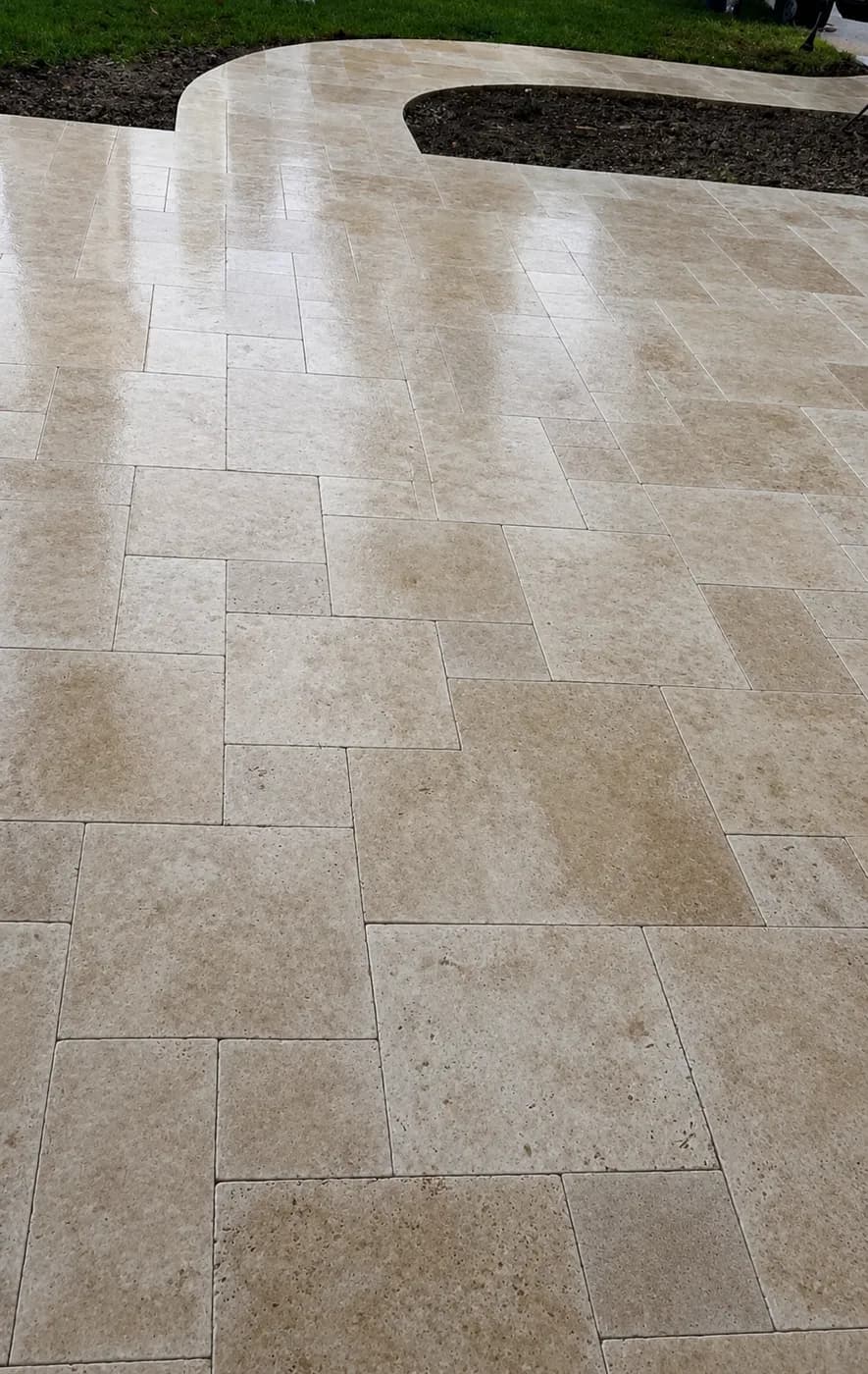 French-pattern travertine after sealing, four stone sizes in a repeating layout.