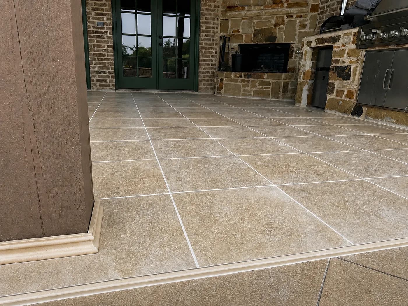 Ivory stone tile floor under a covered outdoor kitchen.